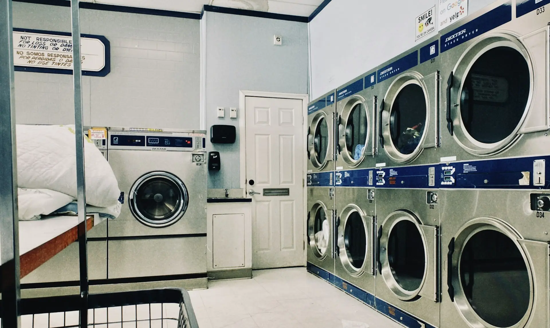 a row of washers and dryers in a laundry room